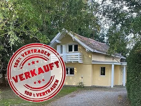 Kleines gelbes Einfamilienhaus mit Bäumen